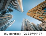 Small photo of Modern glass skyscrapers in Dubai with blue sky in background. Impressive architecture of financial district and Dubai marina.