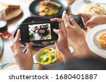 social media and modern people lifestyles. Close up hands of food blogger influencers taking picture of meal dinner post to social media app online in restaurant.