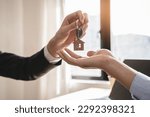 Small photo of close up view hand of property realtor landlord giving key house to buyer tenant.