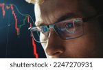 Small photo of Close-up portrait of focused crypto trader analyst wearing eyeglasses looking at computer screen analyzing stock market charts. Eyeglasses reflection cryptocurrency downtrend charts. Bitcoin crash