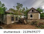 Small photo of Old abandoned ruined house in dead village. Deserted and destroyed dwelling on farm yard. Neglected building countryside