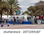 Small photo of Seaside, USA - January 9, 2021: Town of Seaside, Florida in panhandle with retro metal tin restaurant food trucks on airstream row and sign for Gyro Hero restaurant