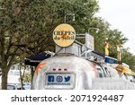 Small photo of Seaside, USA - January 9, 2021: Town in Florida panhandle with retro metal tin restaurant food trucks on airstream row and sign for Crepes du Soleil restaurant