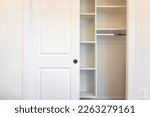 Small photo of Walk-in closet shelves with sliding door in modern minimalist white style with bright light in staging model house apartment bedroom