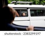 Small photo of Los Angeles, California United States - Oct. 2nd, 2023: A boy smushes his face against a car window at his brother in another car.