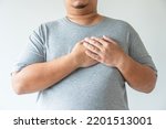 Small photo of Obesity man gain overweight and fat causing to have high risk of heart attack. Fat man pain with heart disease. Man touching his chest at heart position as he get pain from heart problem or sickness.