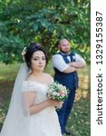 Small photo of Newlyweds on their wedding day stand apart from each other.