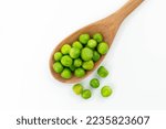 green peas isolated. fresh organic vegetables. on a wooden spoon. top view