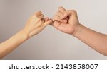 Small photo of Man and woman do Pinky promise or pinky swear hands sign on white background.