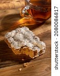 Small photo of Vertical image of bitten termisu biscuit and glass cup of black tes on the wooden table
