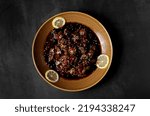 Small photo of Delicious chicken liver in pomegranate source on the brawn bowl, dark colour background,top view.