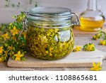 Small photo of St. John's wort flowers macerating in olive oil in a glass jar