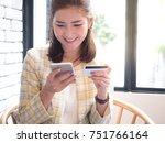 beautiful asian woman holding mobile and credit card in her hands with smiley face. Online shopping concept. 