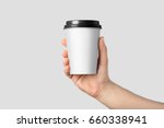 Mockup of male hand holding a Coffee paper cup isolated on light grey background. 