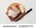 Freshly baked bread cut with knife on a wooden board. top view Sliced bread and knife.
