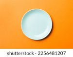 Top view of isolated of colored background empty round blue plate for food. Empty dish with space for your design.