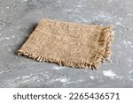 Old burlap fabric napkin, sackcloth on table background. top view with copy space.
