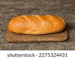 Freshly baked bread on cutting board against white wooden background. perspective view bread with copy space.