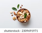Small photo of mixed nuts in bowl. Mix of various nuts on colored background. pistachios, cashews, walnuts, hazelnuts, peanuts and brazil nuts.