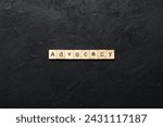 Small photo of ADVOCACY word written on wood block. ADVOCACY text on cement table for your desing, concept.