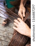 Small photo of Close up of a man doing basketwork, wickerwork. Basketery. Wicker is a technique for making products woven from any one of a variety of cane-like materials. Traditionally made of material of willow.