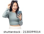 Small photo of Happy and excited young woman using mobile phone standing over isolated on white background and copy space Young girl using smartphone for shopping online chat and texting message She get surprised