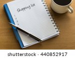 Shopping list written on notebook with cup of coffee, planning conceptual