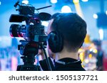 Video operator. Videography.Filming.A man is shooting a video.The work of a videographer. Shooting with a professional camera with a tripod. A man shoots on a professional video camera.Videographer