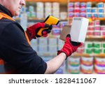 Small photo of Barcodes. A man with a barcode reader near a counter with bright cans. Sale of construction materials. Product encoding.