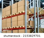 Cardboard boxes on warehouse shelves. Steel racks with pallets. Warehouse of distribution company. Warehouse logistics manufacturing enterprises concept. Concept renting place to store company goods