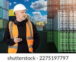 Small photo of Man customs inspector. Worker among sea containers. Guy is customs officer in harbor. Man with phone examines container warehouse. Customs officer waiting for supply goods. Logician near containers