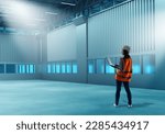 Small photo of Woman in empty warehouse. Logistic storehouse manager. Girl with laptop. Empty warehouse hangar. Woman manager of warehouse company. Metaphor for renting storage hangar. Storehouse supervisor