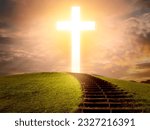 Glowing christian cross. Stairs lead to crucifix. Catholic cross in evening sky. Christian religion. Orthodox faith. Cross on green hill. Concept of places for religious worship. God, lord