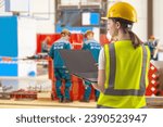 Small photo of Woman industrial engineer. Female industrialist with laptop. Girl in vest and helmet for working in factory. Engineer stands in production workshop. Factory employee with computer. Woman foreman