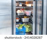 Small photo of Refrigerator with fresh vegetables. Industrial refrigeration chamber. Steel refrigerator in restaurant kitchen. Equipment for food enterprises. Refrigerator with food. Cold chamber for vegetables