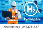 Small photo of Man is engineer at hydrogen factory. H2 logo near technology. Hydrogen energy specialist. Engineer man studies H2 innovation. Industrialist with laptop and phone. Hydrogen power plant technologist