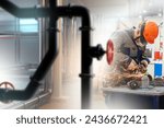 Small photo of Man works in factory. Worker uses grinder. Industrialist produces parts for pipeline. Factory specialist with grinder. Sparks fly during pipe production. Using grinder to grind metal