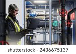 Small photo of Man engineer with laptop. Manufacturing technologist. Experienced engineer in factory basement. Gray-haired man sets up industrial equipment. Chemical factory engineer. Man in industrialist vest