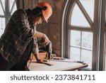 Small photo of a Young man Carpenter works on woodworking machinery in a carpentry shop. The workshop looks professional, highly skilled, and the craftsmen are true craftsmen.