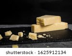 Small photo of Grana Padano italian hard cheese on dark background