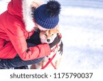 Small photo of Girl embosom dog in her arms. The concept of friendship between a dog and a man. Shiba inu and the girl
