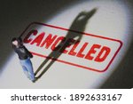 Small photo of Man stands on cancelled stamp with dark shadow. Person is labelled or stereotyped. Cancel culture concept with noise and grain.