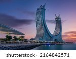 Small photo of Lusail, Qatar - July 21, 2021: Katara buildings crescent Tower view from Lusail Marina Park at sunset time.