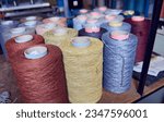 Small photo of Raw spindles of industrial cotton on a weaving factory shelf, hand weaving cotton for the fashion and textiles industry. Yarn weave traditional textile fabric manufacturing for clothing