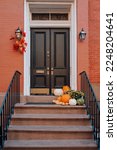 Small photo of Thanksgiving pumpkin decorations on a stoop of a traditional house in Manhattan, New York City, USA.