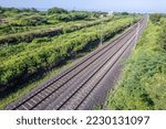 Aerial view of electrified railway tracks on the Pune to Daund route amidst green landscape at Uruli near Pune India.