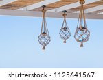 Straw cover the roof of a seaside terrace or veranda with hanging lantern and view to blue sky.many light bulbs decorated with ropes, net at the ceiling of the restaurant