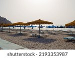 Empty beach with umbrellas and sunbeds. selective focus.The low season.Summer vacation and Covid-19.Beach without people. concept idea for vacation, holiday