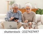 Small photo of Middle aged senior couple sit with laptop and paper document. Older mature man woman reading paper bill pay online at home managing bank finances calculating taxes planning loan debt pension payment