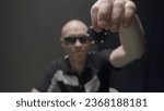 Small photo of Man drops chip on poker table. Action. Bandit with glasses drops chip on pile of chips on poker table. Gambling and crime
